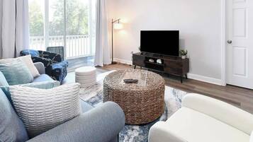 Een woonkamer met een bank, een salontafel en een televisietoestel op een meubel.