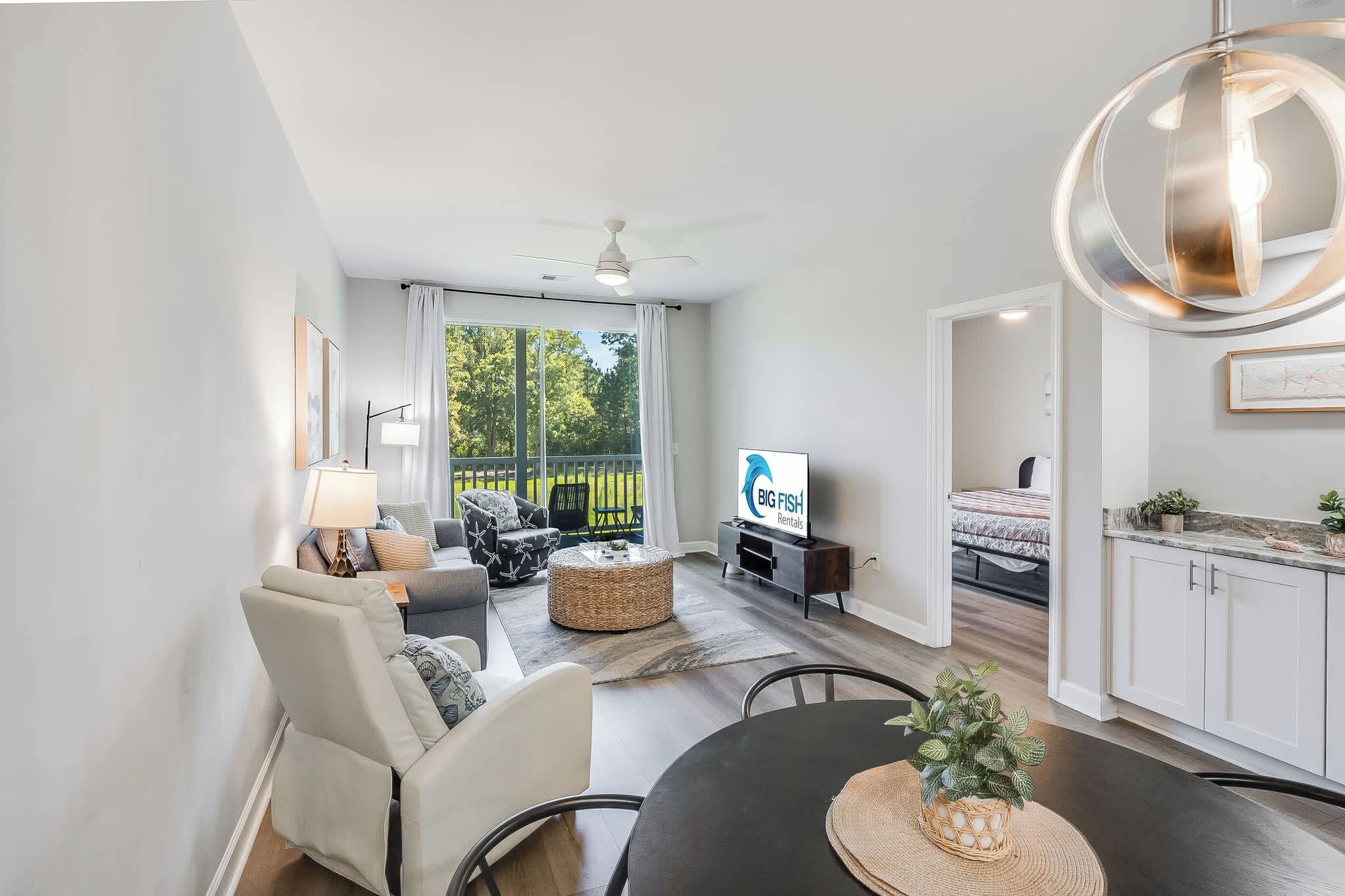 Una sala de estar moderna con un sofá, sillones, una mesa de comedor y un televisor.