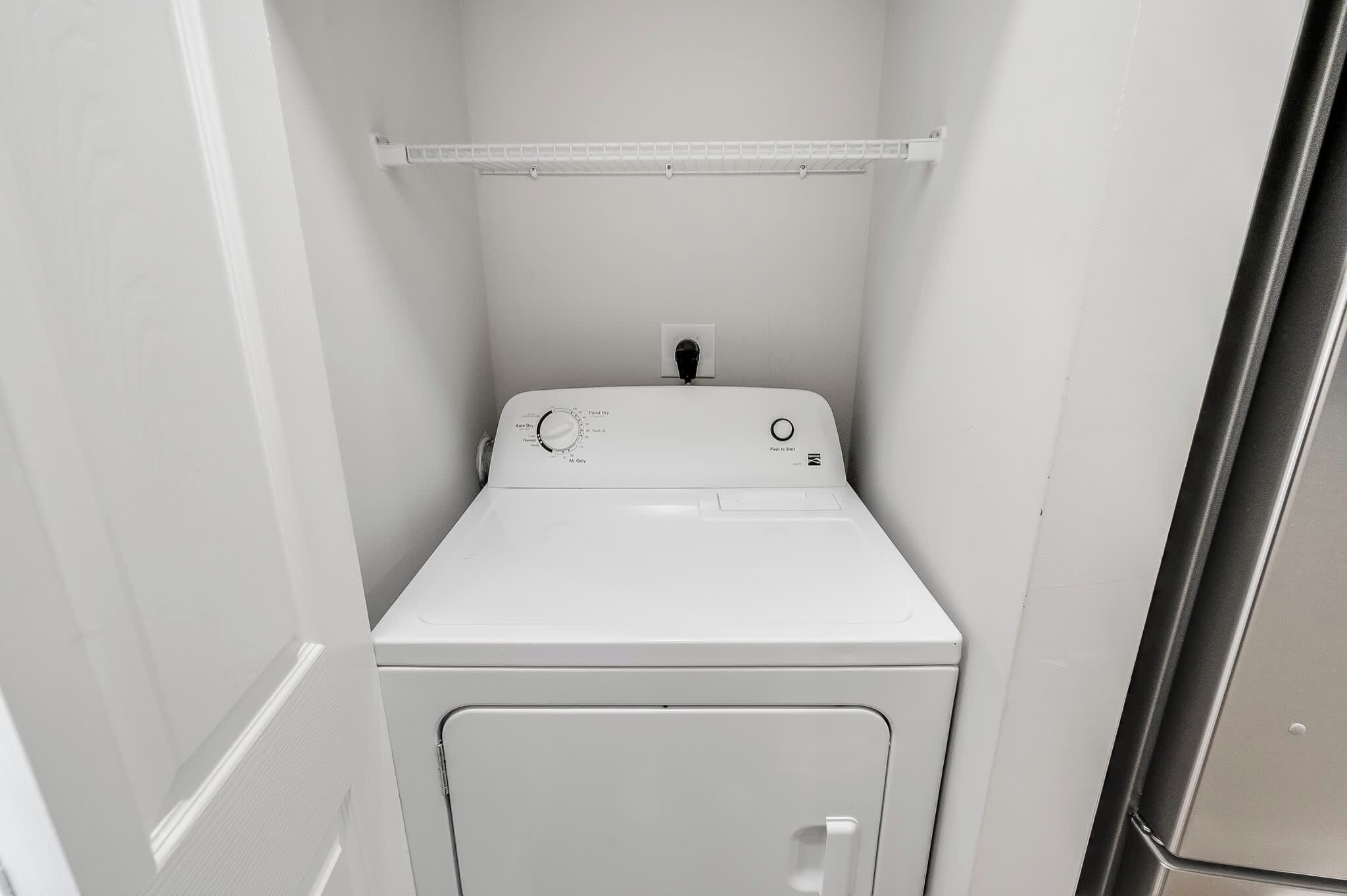 A compact, white, wall-mounted washer and dryer unit with a control panel featuring various settings.