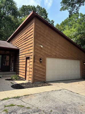 Un bâtiment d’un seul étage, doté d’une porte de garage, d’une enseigne d’accueil et d’un petit jardin.