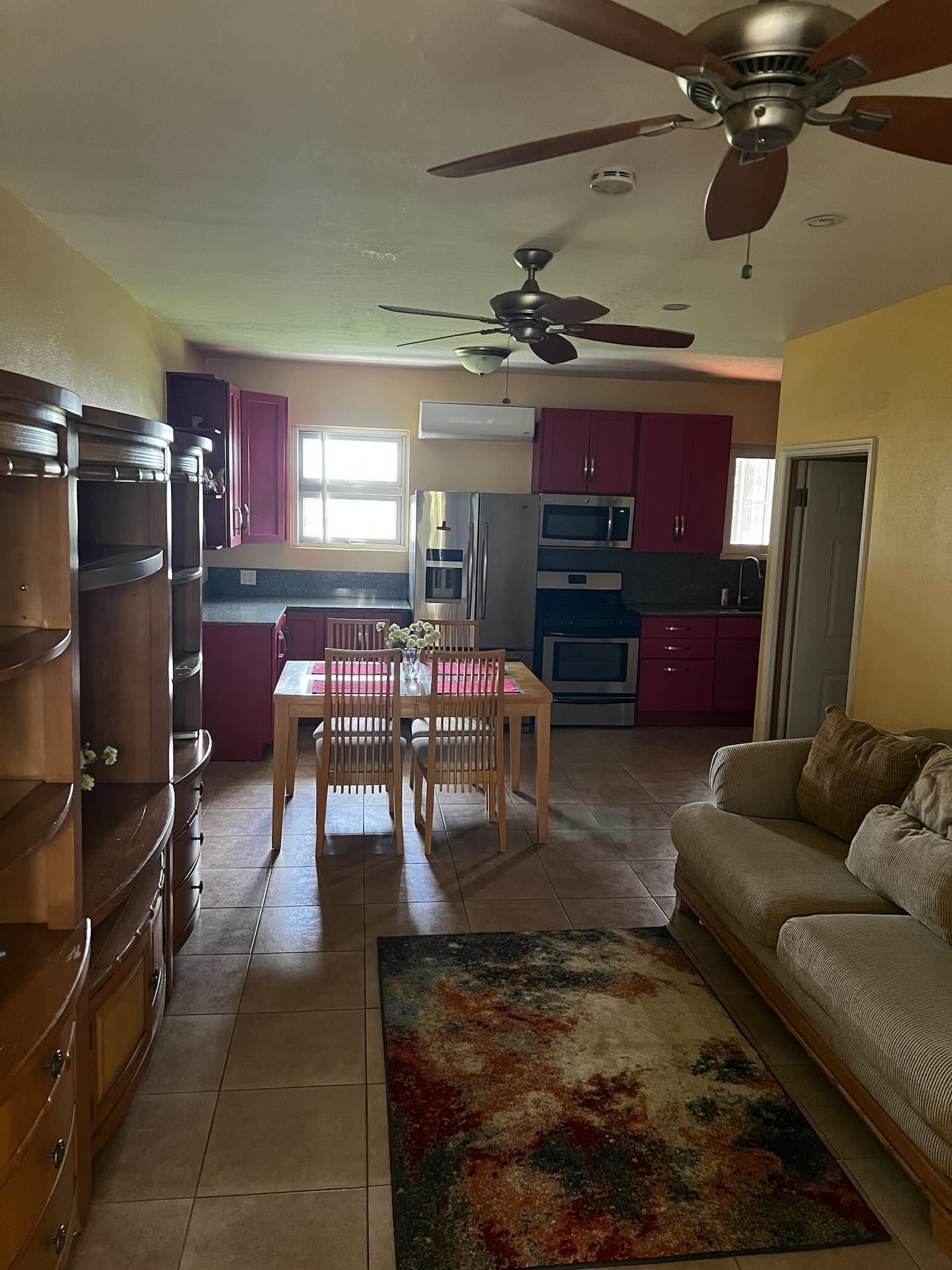 A kitchen with a dining table, chairs, and a ceiling fan.