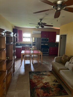 A kitchen with a dining table, chairs, and a ceiling fan. - Charming 1-bedroom apartment, near the Airport, great for travel connections (Nassau)