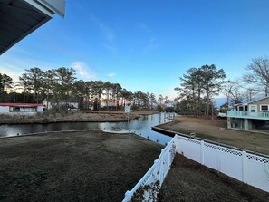 A residential area with a body of water, a dock, and a white fence.