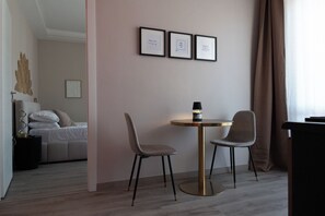 A hotel room with a bed, a desk with a lamp, two chairs, and three framed motivational quotes on the wall. - VELARIS LUXURY SUITE & SPA - Self-Check-In (Bologna)