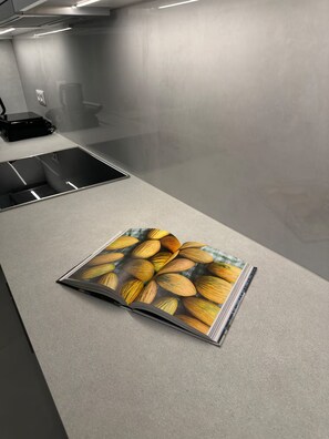 A kitchen counter with a magazine featuring almonds. - Parkside Residence (Vironas)