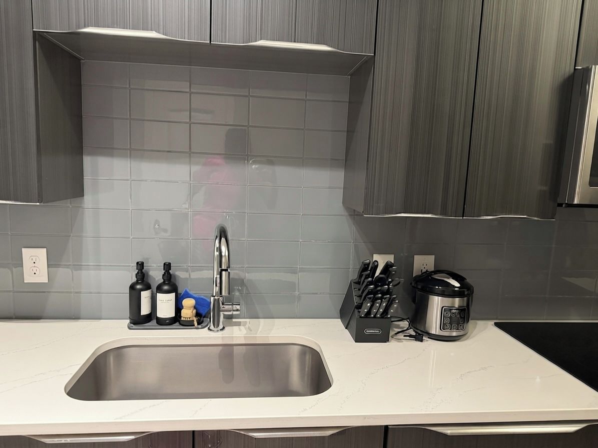 A modern kitchen with a stainless steel sink, a coffee maker, and a knife block.