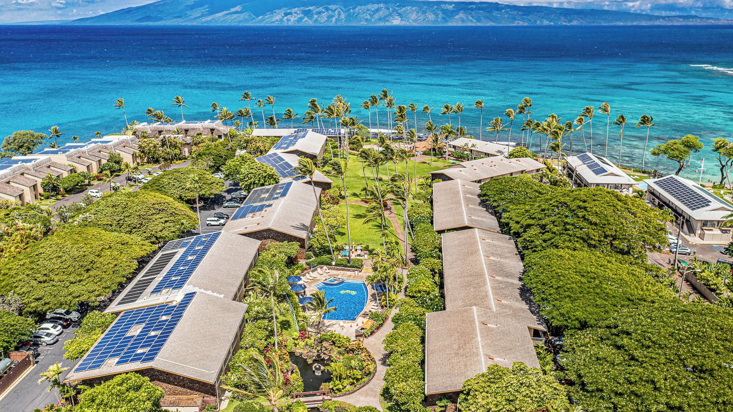 Een resort met meerdere gebouwen, een zwembad en zonnepanelen.