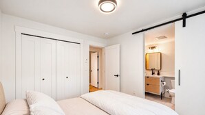 Una camera da letto con un letto, un armadio e un bagno con il water e un lavandino.