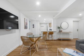 A modern interior with a dining area, kitchen, and living space. - Banksia on the Beach (Gold Coast)
