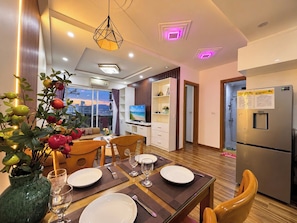 Una sala moderna con comedor, televisor y cocina.