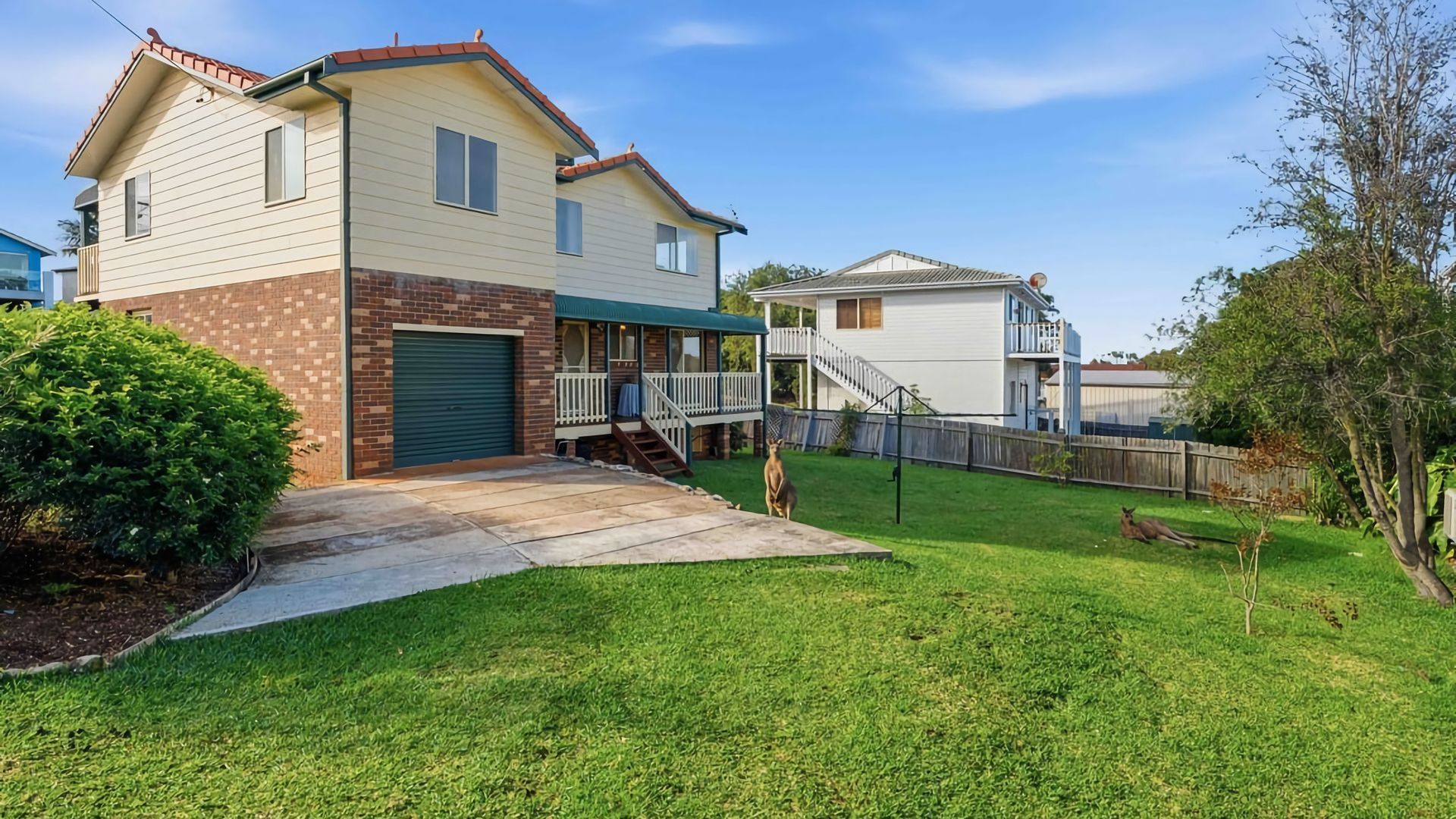 A two-story house with a front porch, a garage, and a fenced backyard.