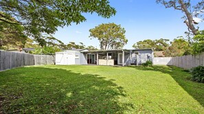 A backyard with a small shed, a barbecue area, and a fenced yard. - The Butterfly House is located in the heart of Bendalong (Bendalong)