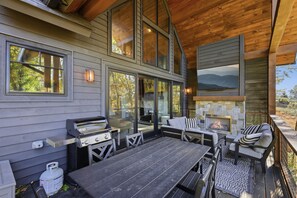 An outdoor patio with a grill, seating, and a stone fireplace. - Black Diamond  Luxury Unwind: Hot Tub, Game Room, Sleeps 14 (Banner Elk)