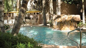 A pool area with a waterfall feature, lounge chairs, and umbrellas. - Walk to WM Phoenix Open & the Bird's Nest! Luxury 1BR Villa (Scottsdale)