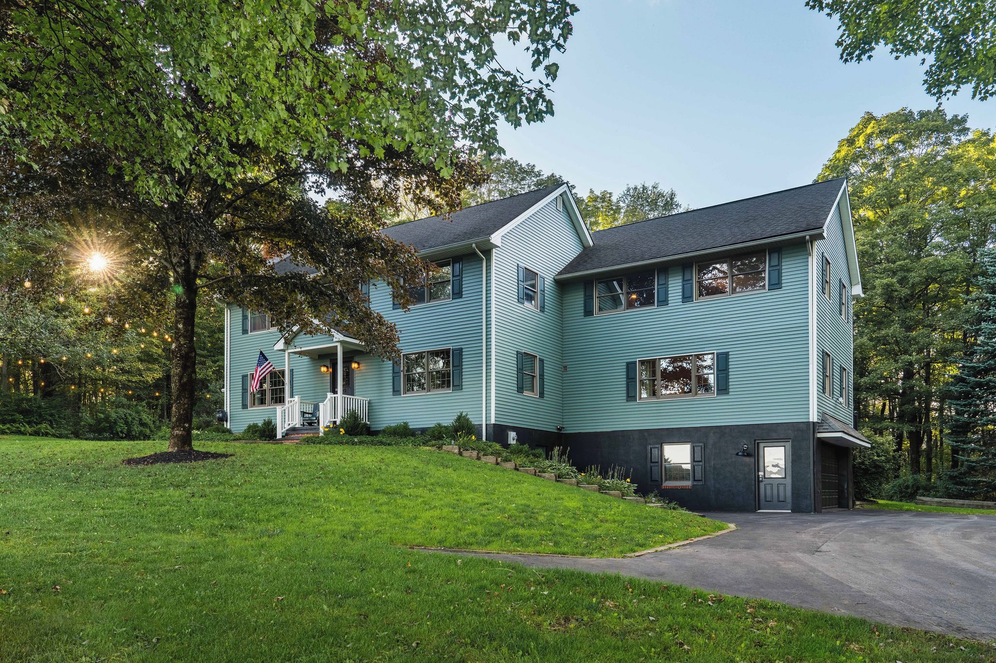 A two-story house with a porch and a driveway.