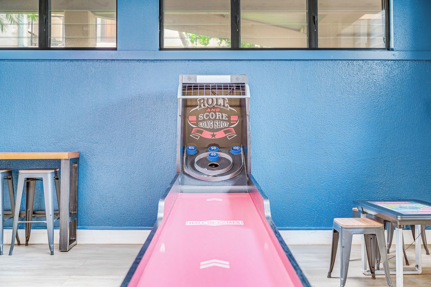 Een jeu de boules tafel met een 'ROCKETS' bord, twee metalen krukken en een tafel met een 'HATRED GAMES' bord.