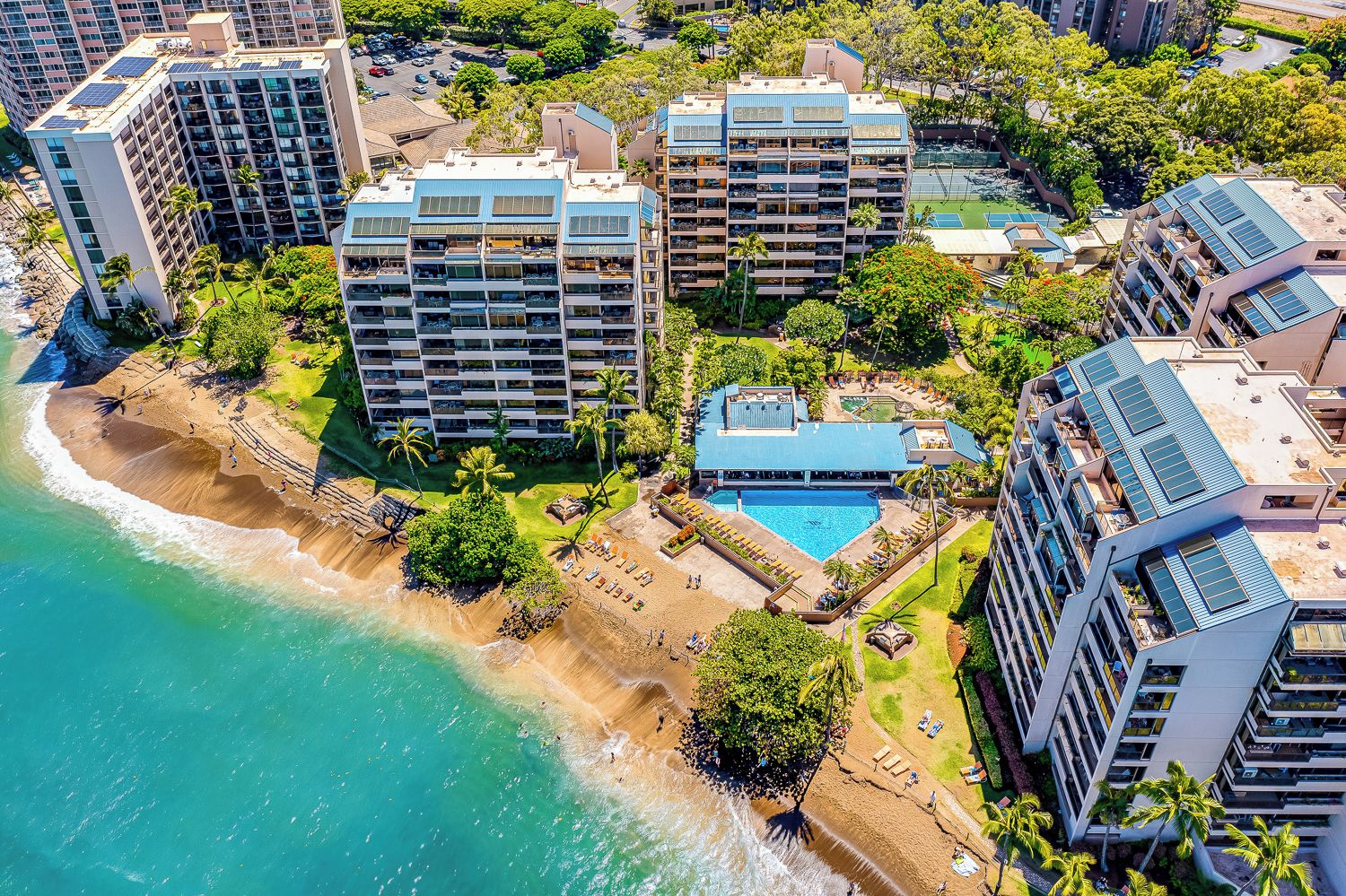A coastal hotel with multiple high-rise buildings, a beach, and a pool area.