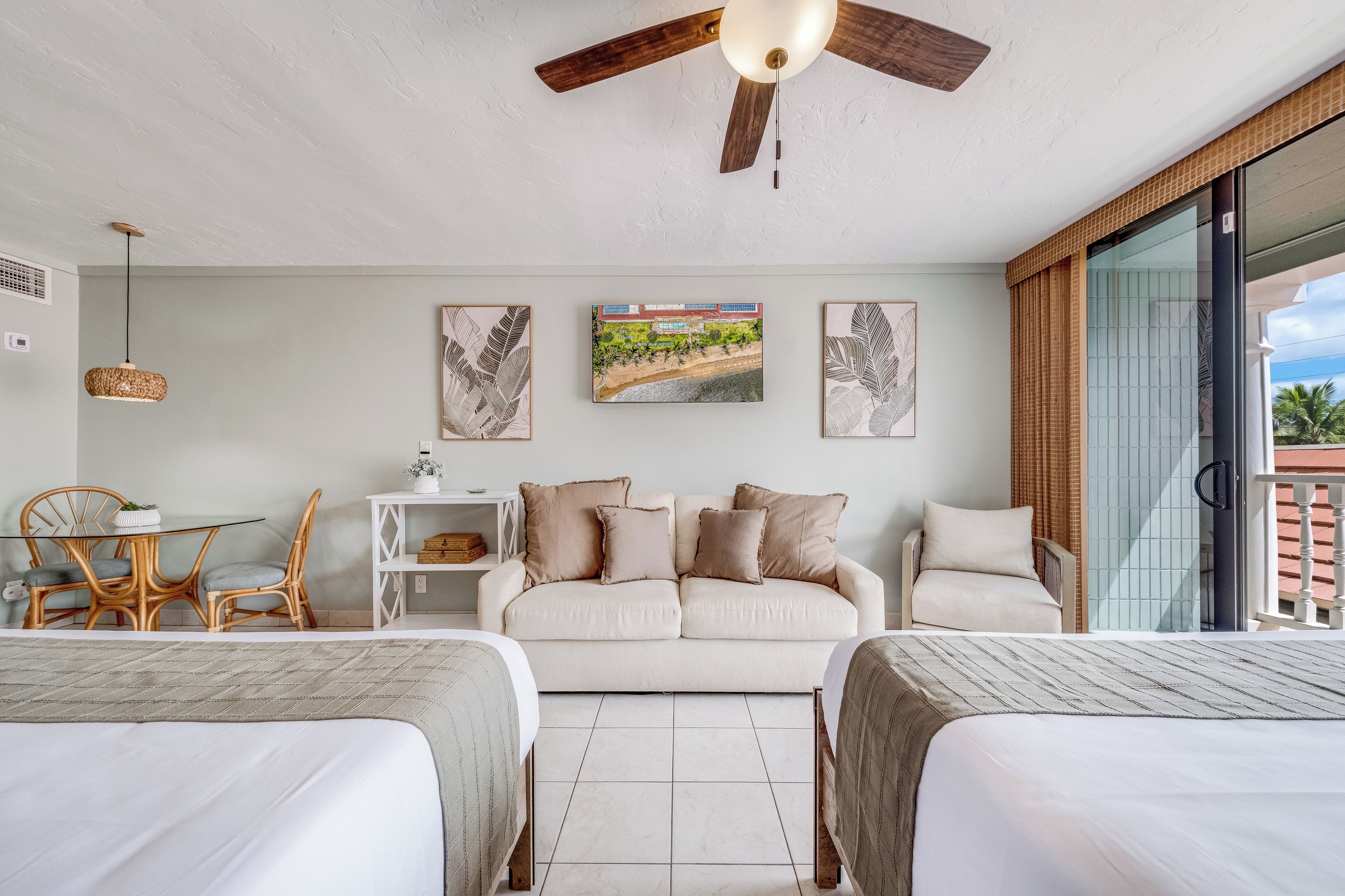 Een moderne slaapkamer met een bed, een bank, een eettafel met stoelen en kunst aan de muur.
