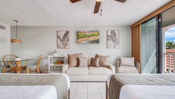 Een moderne slaapkamer met een bed, een bank, een eettafel met stoelen en kunst aan de muur.