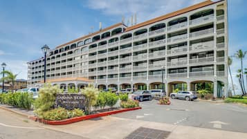 Un hôtel à plusieurs étages doté de balcons et d’un panneau indiquant un complexe hôtelier en bord de mer.
