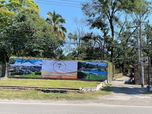 A hotel sign with a pool and outdoor seating area.