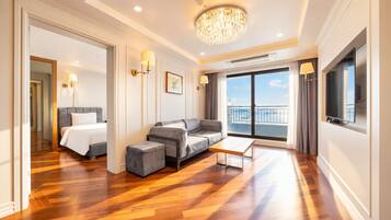 Een moderne hotelkamer met een bed, een bank, een voetenbankje en een balkon met uitzicht.