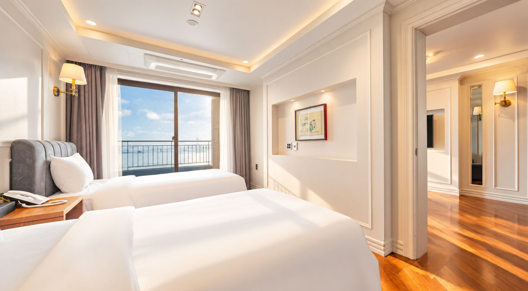 Een hotelkamer met twee bedden, een balkon en uitzicht, en een modern design.