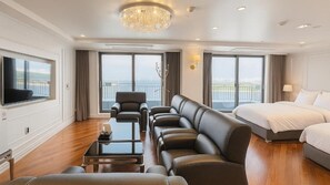 A modern hotel room with a large bed, a sofa, a TV, and a balcony with a view. - Incheon Grace Hotel (Incheon)