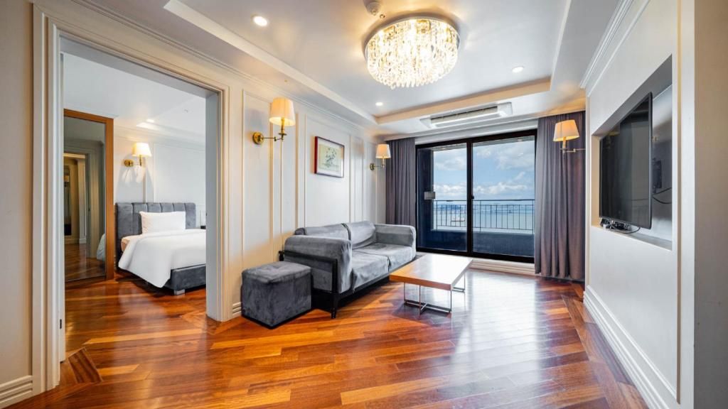 Een moderne hotelkamer met een bed, een bank en een balkon met uitzicht.