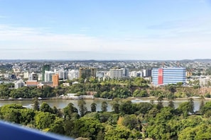 A cityscape with a river, buildings, and greenery. - Queen's Wharf Residences Luxury 2 Beds 1 Car (Brisbane)