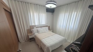 Una camera d'albergo con un letto, un comodino e una lampada a soffitto.