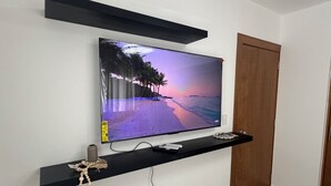 Una TV a schermo piatto montata a parete mostra una scena di spiaggia.