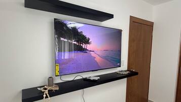A flat-screen TV mounted on a wall with a beach scene on display.