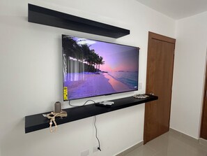 Un televisor de pantalla plana montado en una pared, mostrando una escena de playa.