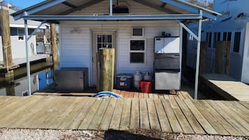 En liten, envåningsbyggnad med en inglasad veranda, en dörr och ett fönster.