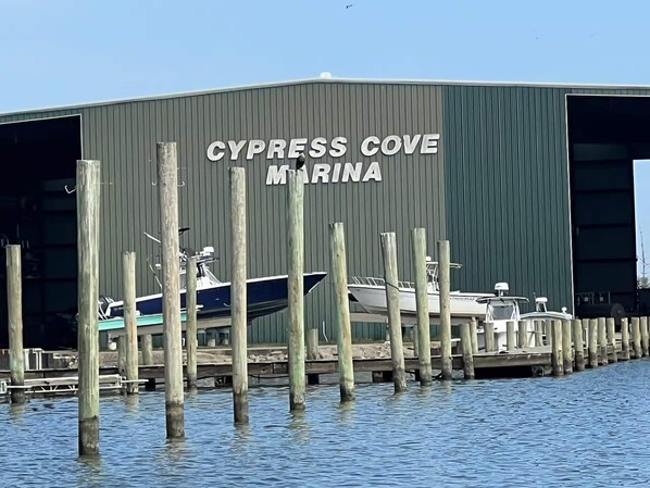 A marina with boats docked in front of a building labeled 'CYPRESS COVE MARINA'.