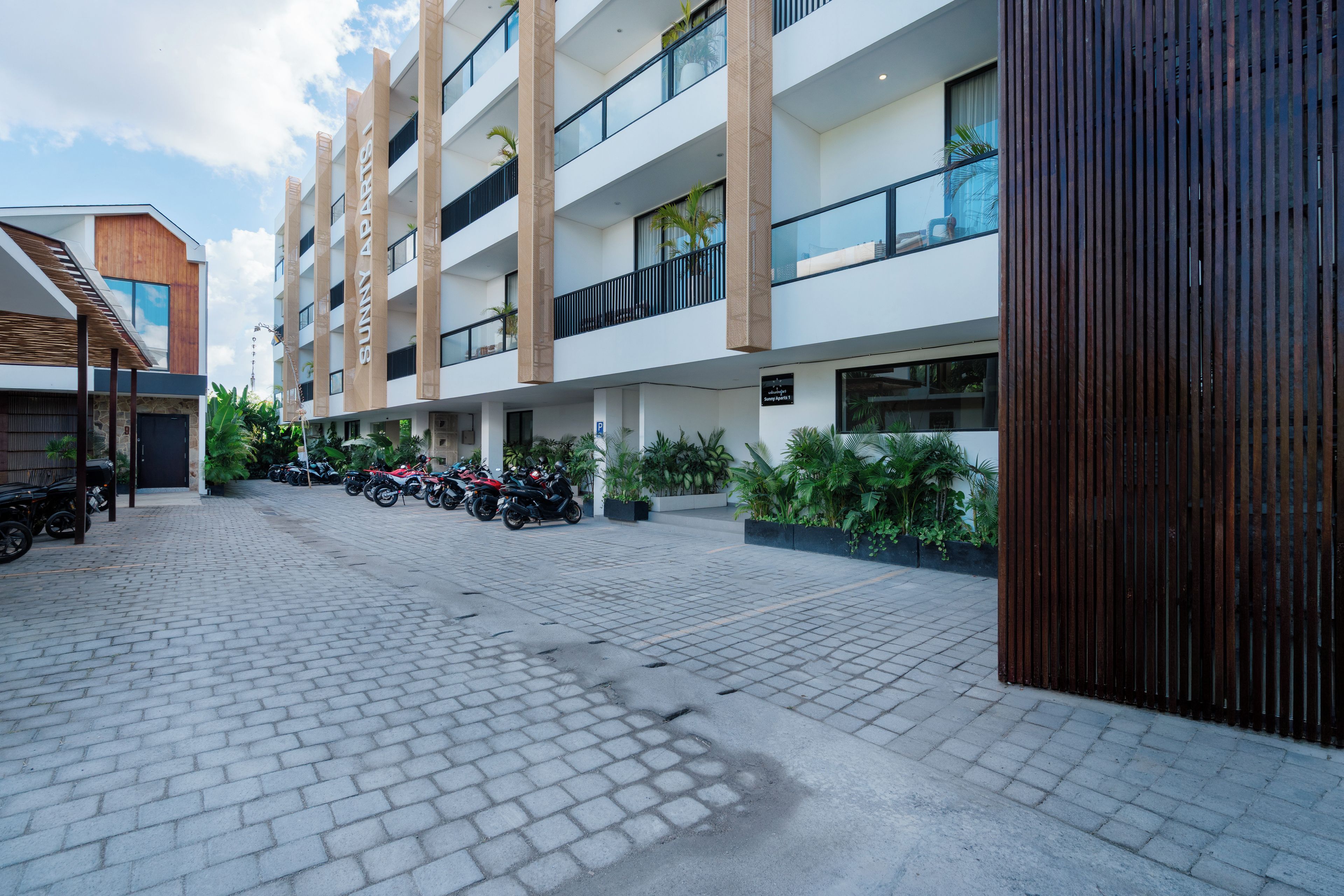 A modern multi-story building with a parking area.