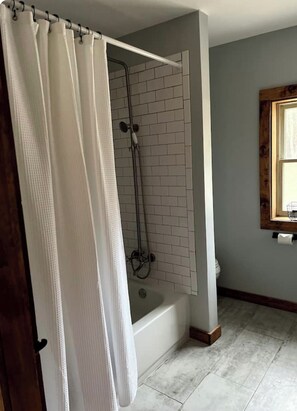 Ein Badezimmer mit Dusche, Badewanne und Toilette.