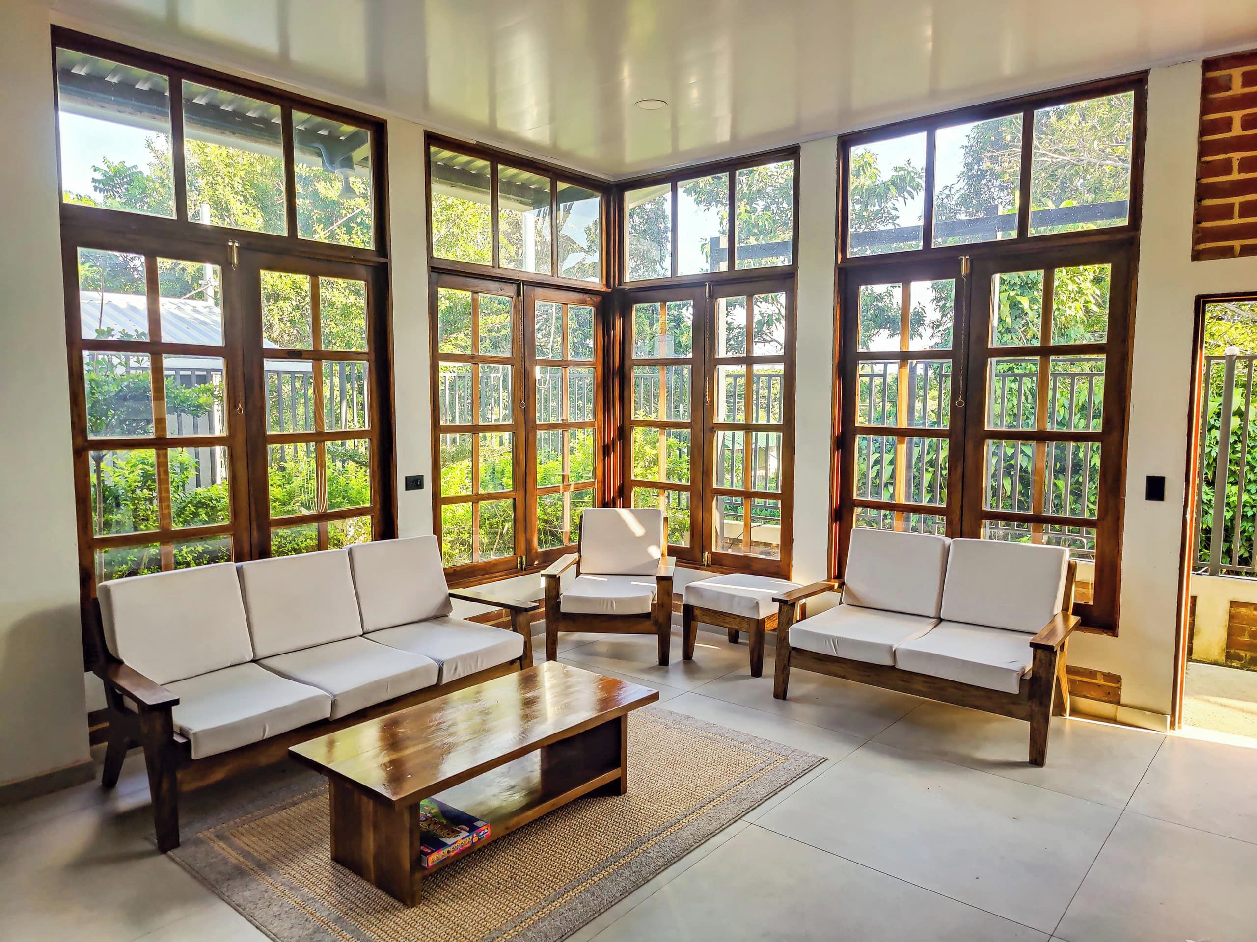 A spacious room with large windows, a sofa set, and a coffee table.
