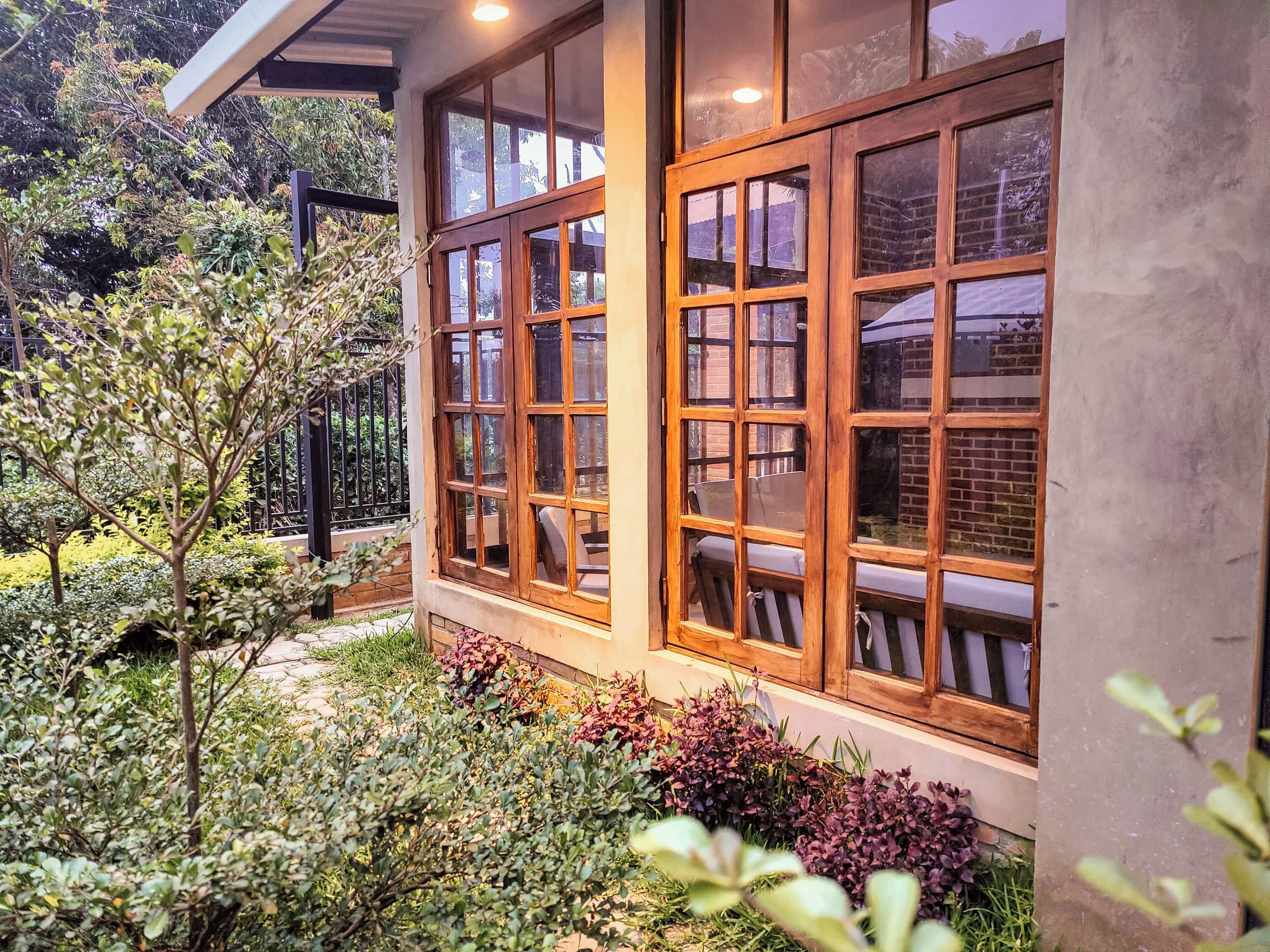 A building with large windows and a garden area with various plants.