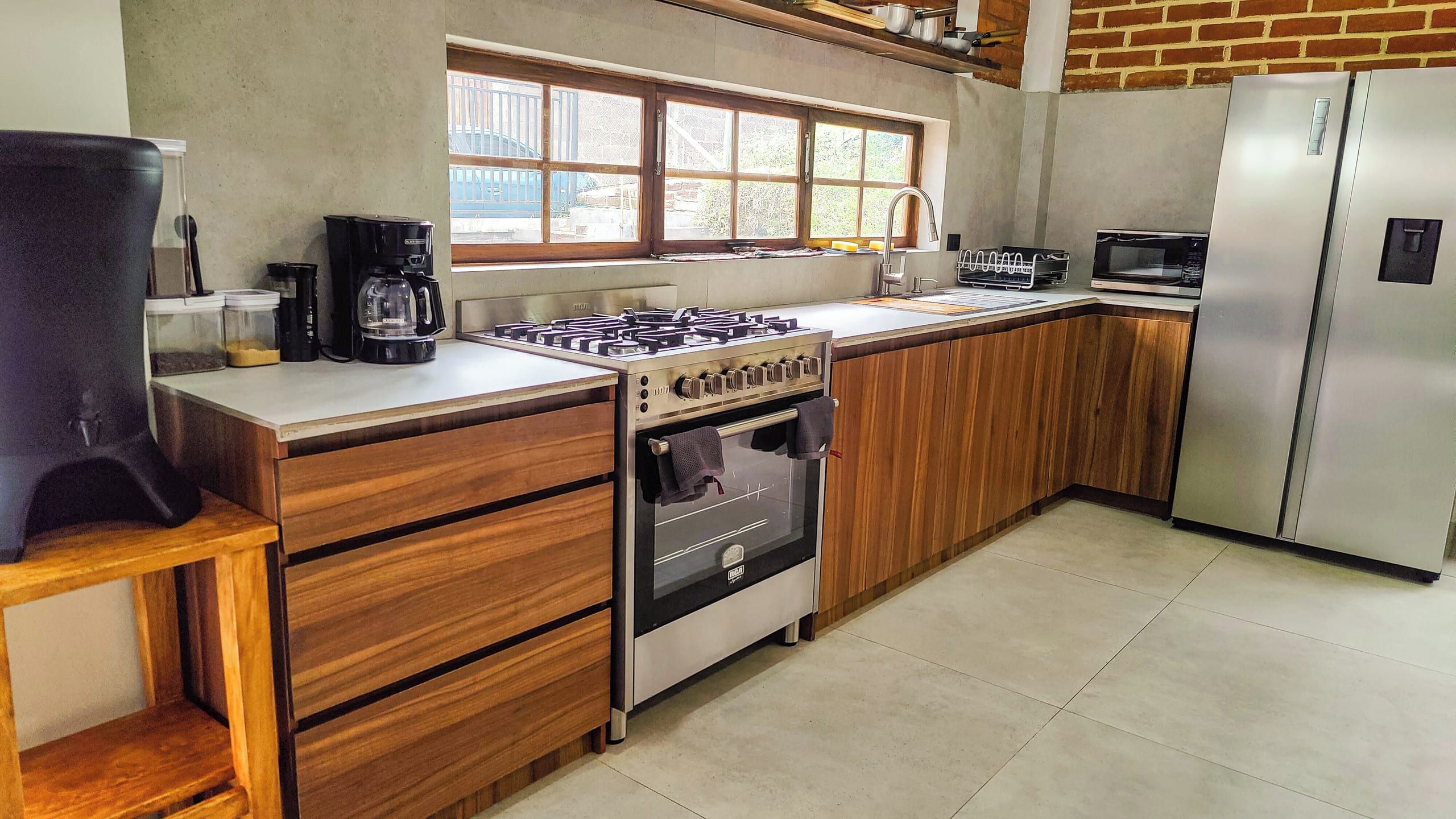 A modern kitchen with a gas stove, oven, microwave, and a refrigerator.
