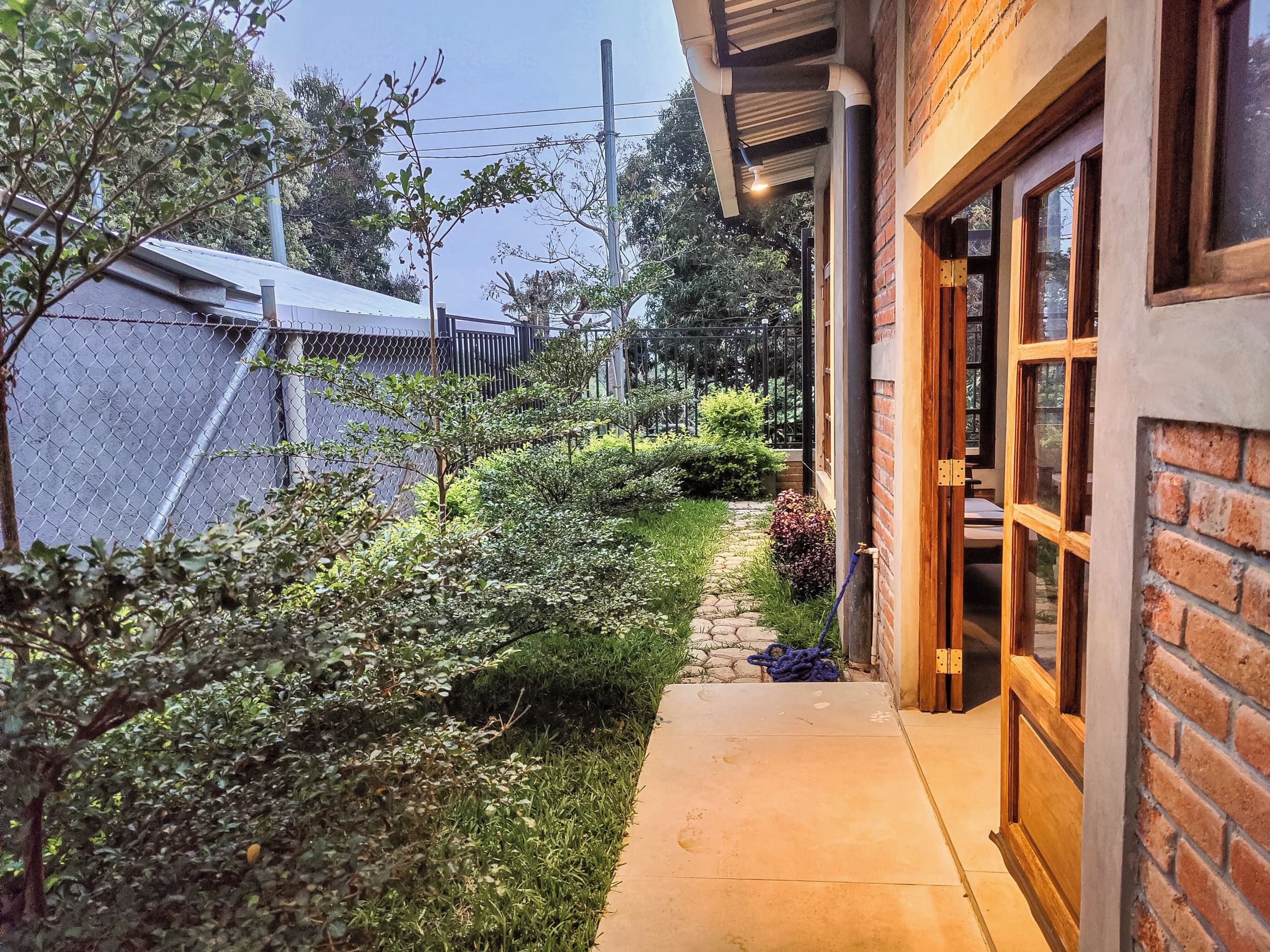 A pathway leading to a building with a brick exterior and a wooden door.