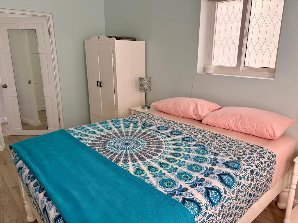 Een slaapkamer met een bed, een kledingkast, een nachtkastje en een raam.