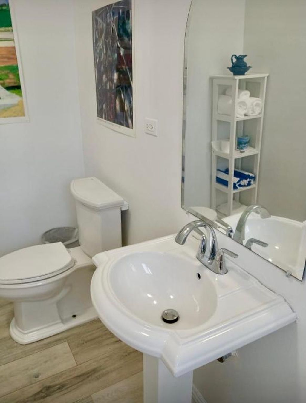 A bathroom with a toilet, sink, and mirror.