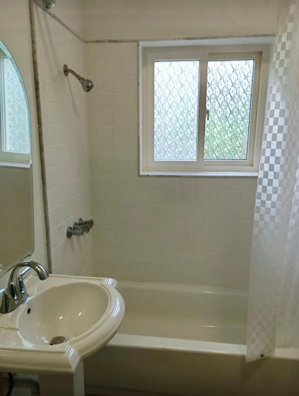 Ein Badezimmer mit einer Badewanne, einem Waschbecken, einem Fenster und einer Duschvorhang.
