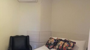 A hotel room with a bed, a chair, and an air conditioning unit. - O Canto Pousada (Piranhas)