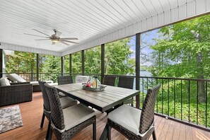 Un patio techado al aire libre con una mesa y sillas, con vistas a un paisaje natural.