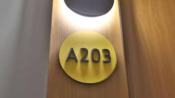 Señal circular con el número 'A203' sobre superficie de madera.