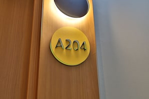 Un letrero circular con el número 'A204' sobre una superficie de madera.