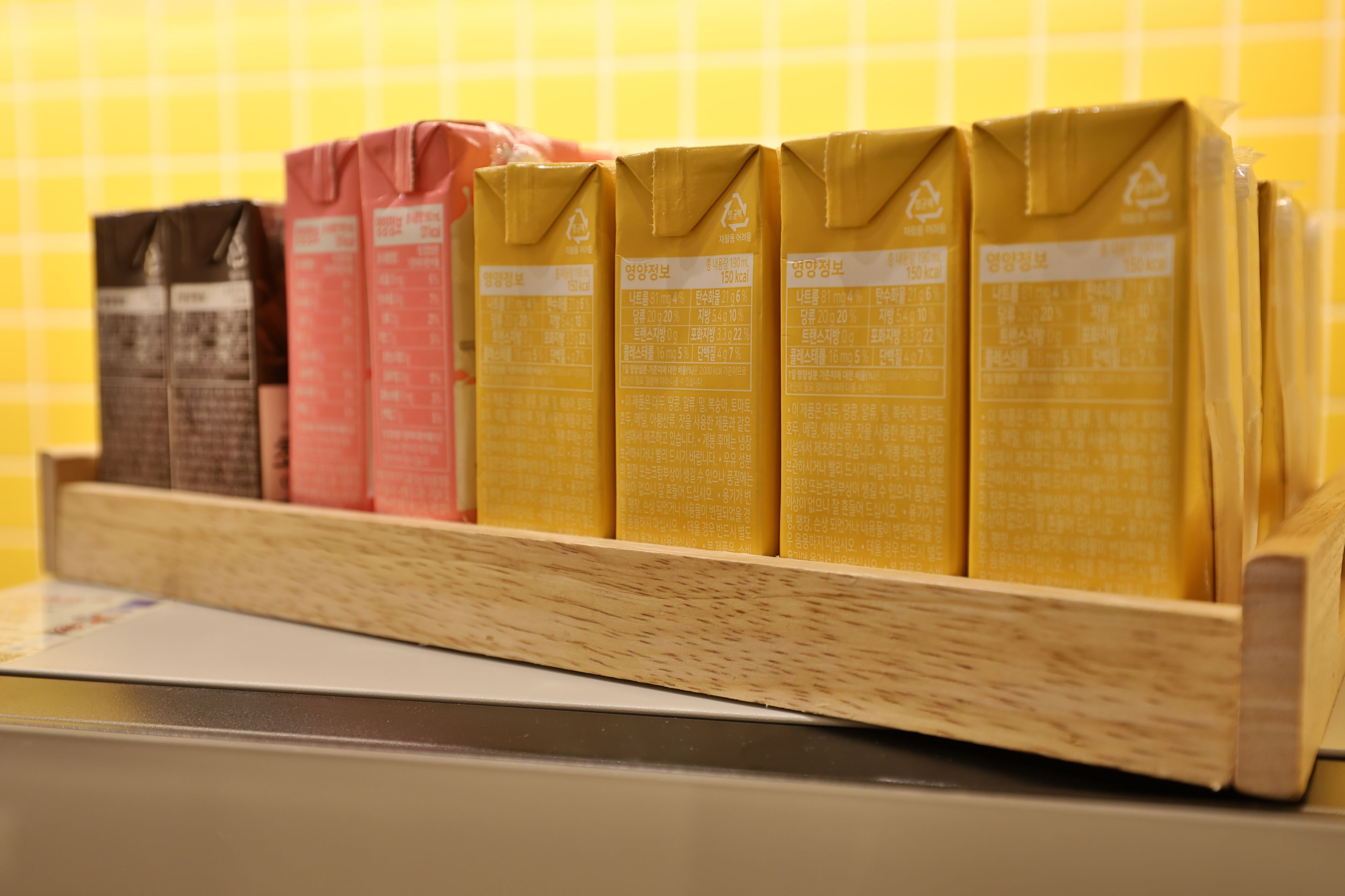 A shelf with cartons of beverages, likely milk or juice, in different colors.
